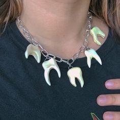 Made to order teeth charm necklaces! A must-have alternative accessory for every occasion!  These human teeth charms are individually crafted by me from natural Versa ceramic clay, fired in a kiln, painted and glazed, then fired again in a kiln at 2,000 degrees to achieve a hard, durable, smooth & stone-like texture. Each made-to-order necklace includes five unique ceramic teeth charms, dangling across shiny, silver stainless steel chunky, oversized chain for a gothic, punk look.  Sizes;  Choker length- 15-16 inches Medium chain length- 17-18 inches Long chain length- 19-20 inches gothic jewelry y2k alternative teeth tooth jewelry oddities curiosities made to order clay statement goth alt dollskill pastel goth 90s 2000s chain funky thick asymmetrical silver gold one of a kind unique one of Chunky Chain Jewelry, Goblincore Necklace, Silver Clay Jewelry Ideas, Teeth Charms, Teeth Accessories, Jewellery Portfolio, Tooth Fairy Costumes, Ceramic Chain, Teeth Necklace