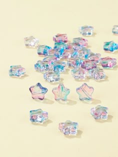 many different shapes and sizes of glass beads on a white surface with light colored background