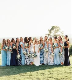 a group of women standing next to each other on top of a lush green field