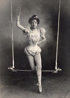 an old photo of a woman swinging on a swing with her hands in the air