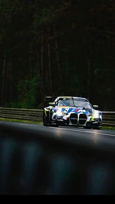 a car driving on a race track with trees in the background