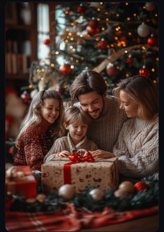 a man and two children opening a christmas present