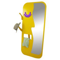 a yellow mirror with a purple face holding a hat and a small gray object in it's hand