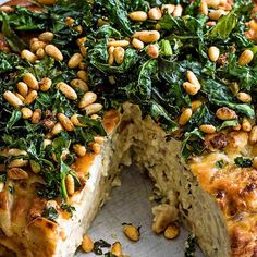 a close up of a cake on a plate with one slice cut out and topped with greens