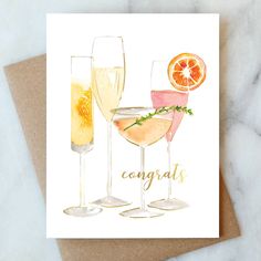 two champagne glasses with an orange slice and the words congrats