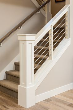 a stair case in a home with wood floors and white railings on the stairs