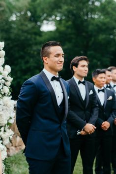 a group of men in tuxedos standing next to each other