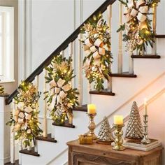 christmas decorations on the banisters and stairs with lit candles in front of them