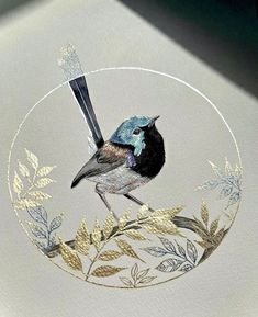 a bird sitting on top of a glass plate covered in gold and blue leaves,