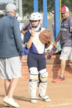 a woman holding a catchers mitt on top of a field