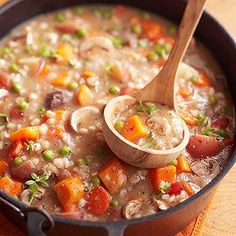 a wooden spoon in a pot filled with soup