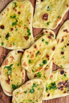 several flat breads with green herbs on them