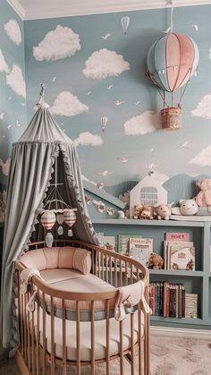 a baby's room with a crib, bookshelf and hot air balloons on the wall