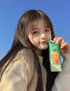 a young woman holding onto a tube of toothpaste