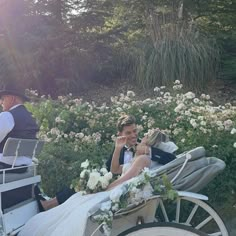 the bride and groom are riding in a horse - drawn carriage with flowers all around them