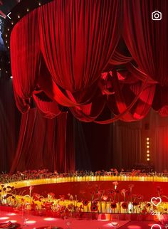 an empty stage with red drapes and tables set up for a wedding or special event