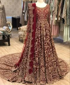 a red and gold wedding gown on display in a store with mannequins