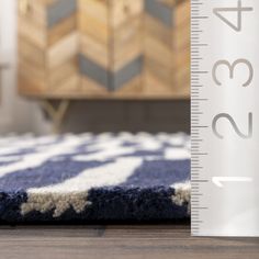 a blue and white rug next to a ruler