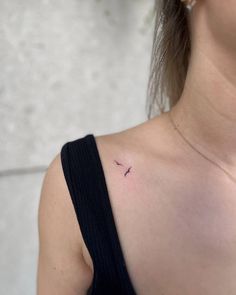 a woman with a small bird tattoo on her chest