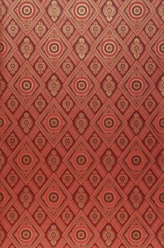 a red and gold wallpaper with an intricate design on the bottom half of it