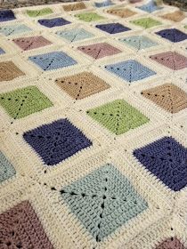 a crocheted blanket that has squares on it