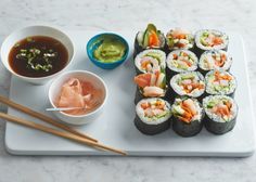 sushi and dipping sauces on a white tray