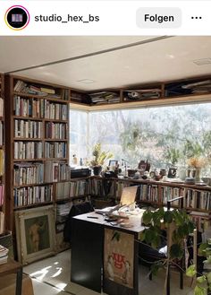 a home office with lots of bookshelves and plants in the window sill