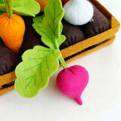 a close up of an object made out of felt with leaves and fruit on it