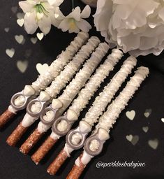 four wedding garters are arranged on a table with white flowers and heart - shaped confetti