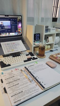 an open laptop computer sitting on top of a desk next to a calculator