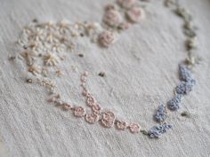 a close up of a piece of cloth with beads and flowers on the bottom half