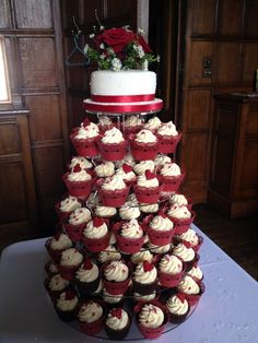 a tower of cupcakes with red and white frosting