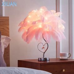 a lamp that is sitting on top of a table next to a bed and window