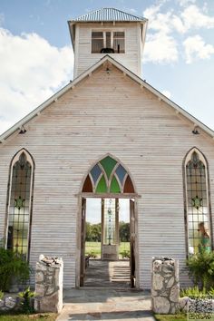 an old church with stained glass windows and stone steps leading to the front door is shown