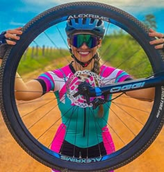 a woman is holding her bike up to the camera