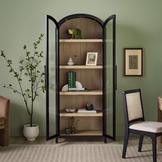 a room with green walls and a wooden bookcase filled with books on top of shelves