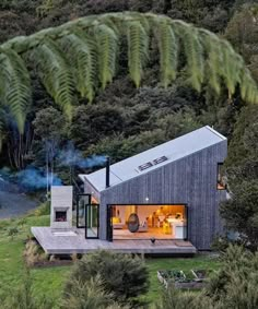 an aerial view of a small house in the middle of some trees and grass, surrounded by greenery