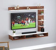 a flat screen tv mounted to a wall in a living room with shelves on both sides