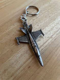 a metal cross keychain sitting on top of a wooden table