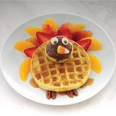 a plate with waffles and fruit on it that is shaped like a turkey