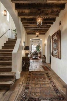 a hallway with wooden floors and stairs leading up to the second floor in an old house