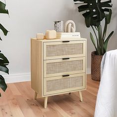 a white bed sitting next to a wooden dresser on top of a hard wood floor