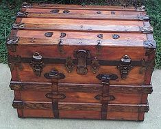 an old wooden trunk sitting on the ground