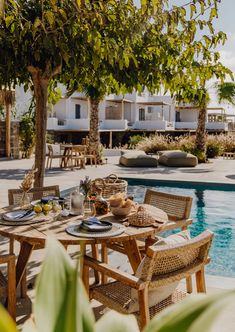 an outdoor dining table next to a swimming pool