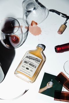 a bottle of liquor sitting on top of a table next to wine glasses and other items