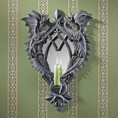 a candle is lit in front of a mirror with an intricate dragon design on it