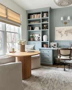 a living room filled with furniture next to a window covered in blinds and bookshelves