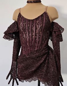 a mannequin wearing a purple dress with ruffles on the shoulders and long sleeves