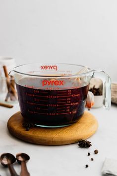 a measuring cup filled with liquid on top of a wooden board