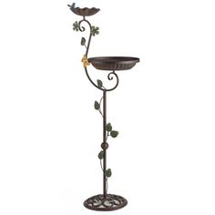 a decorative metal candle holder with two birds on it's top and leaves in the bottom